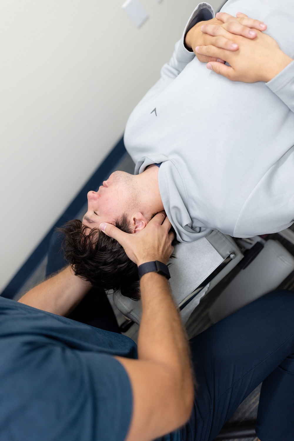 Chiropractor cradling a patient's head and neck during a treatment session 